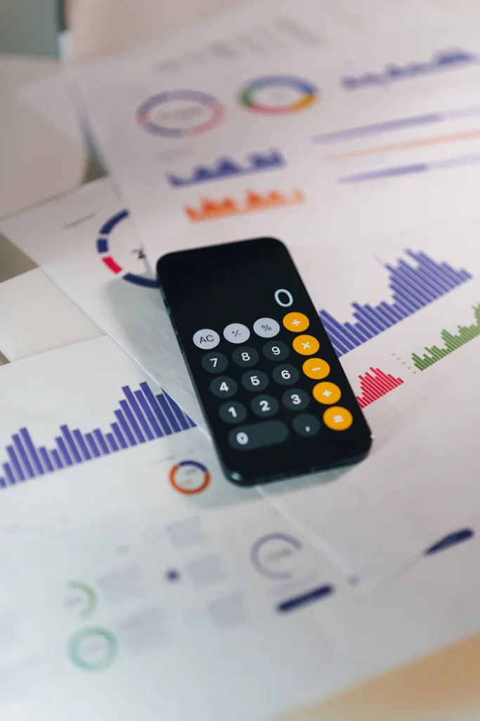 A calculator resting on printed financial reports