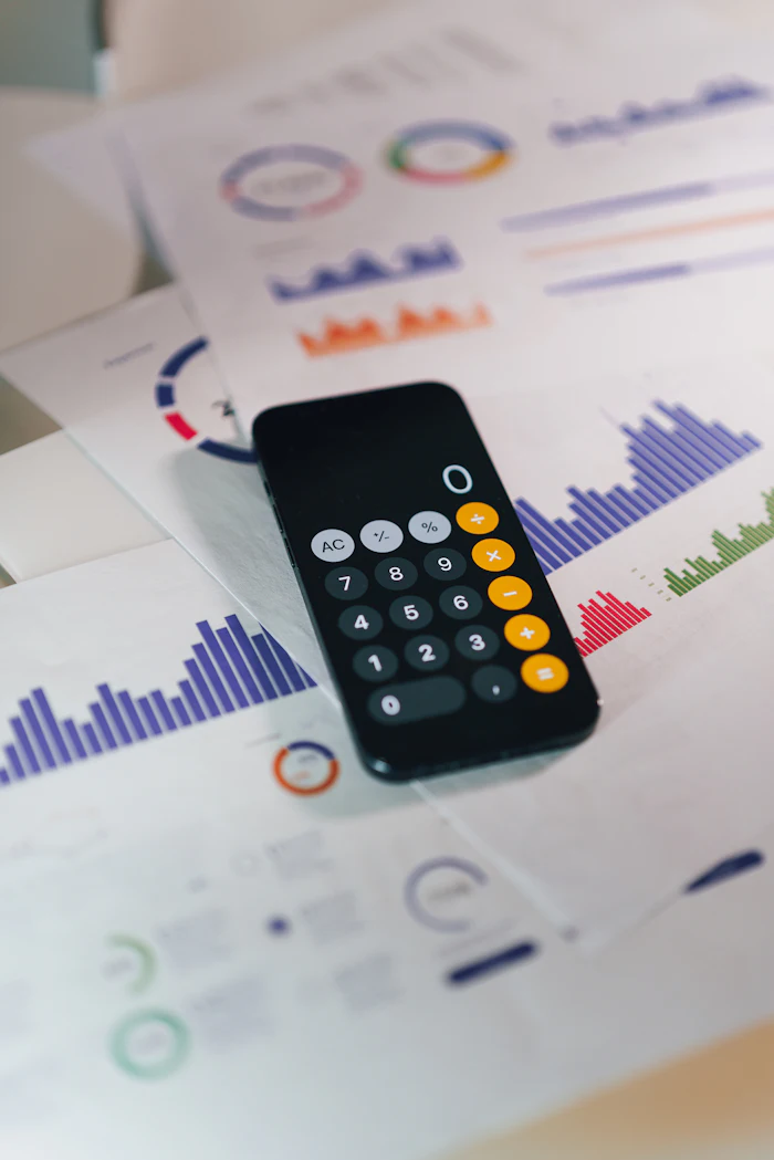 A calculator resting on printed financial reports