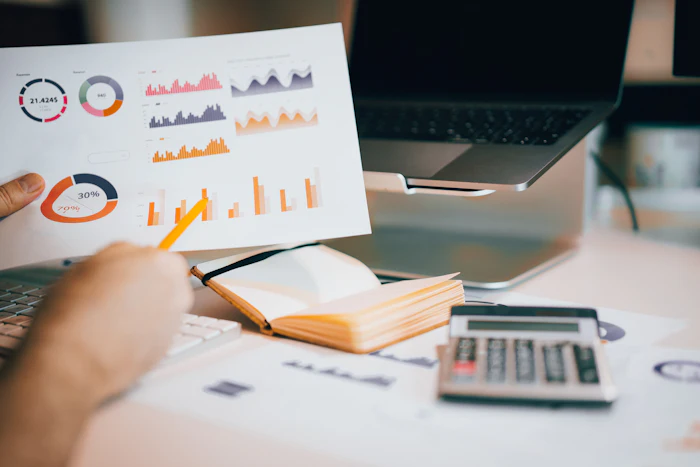 An advisor reviewing financial charts beside a laptop